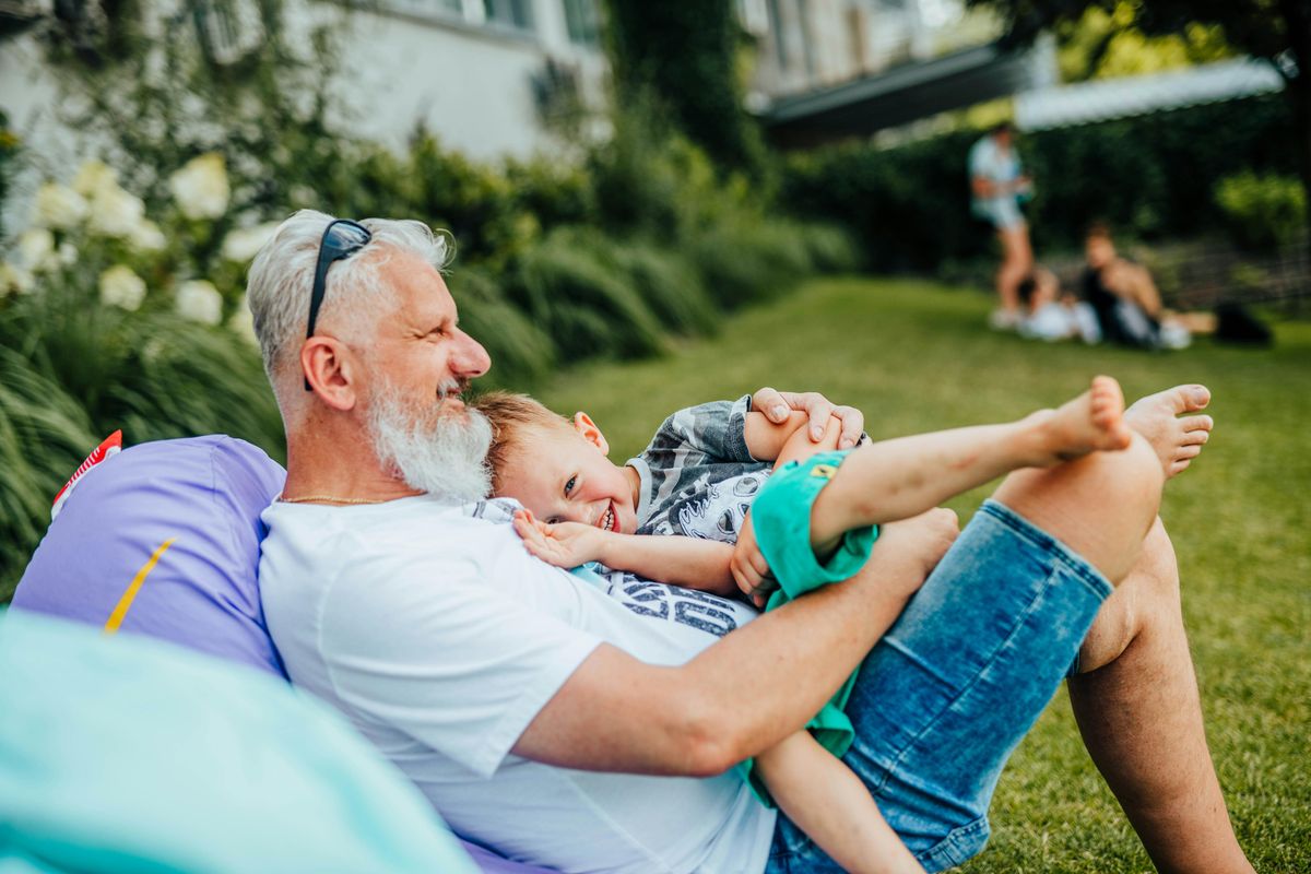 grandfather holding smiling grandson